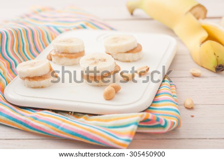 banana slices with peanut butter on white chopping board