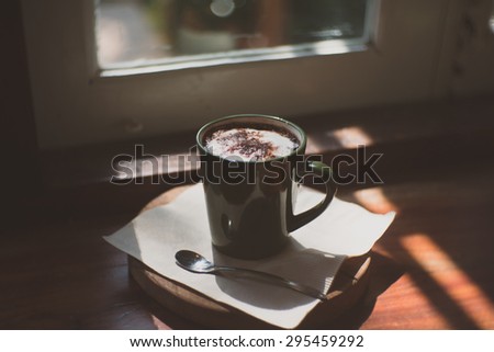 Feel lonely with vintage Coffee cup  on a wooden table In the Morning Against Bright Curtained Windows