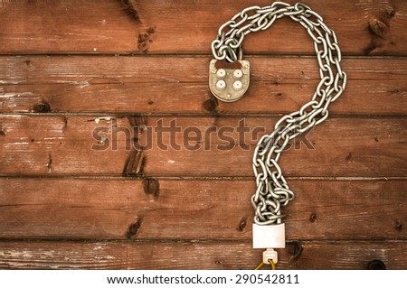 Chain  on a rustic wooden background. Interrogation point