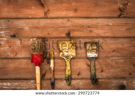 Set of old brush for coloring the walls. Brush painting on wooden furniture, close up. Paintbrush on wood background