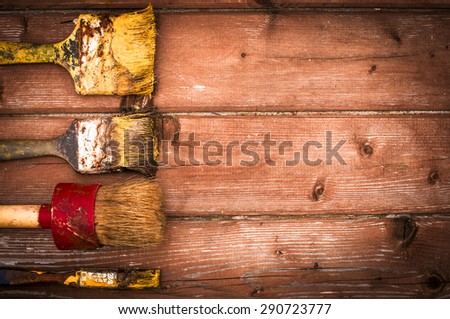 Set of old brush for coloring the walls. Brush painting on wooden furniture, close up. Paintbrush on wood background