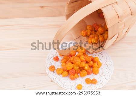 Ripe cloudberry crumbled from a wicker basket