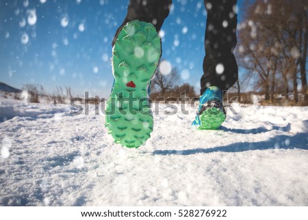 Winter running exercise. Runner jogging in snow.