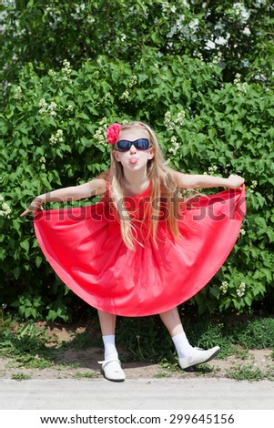 fashion small girl in red dress making a face