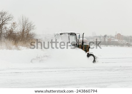 Tractor cleaning snow on the road
