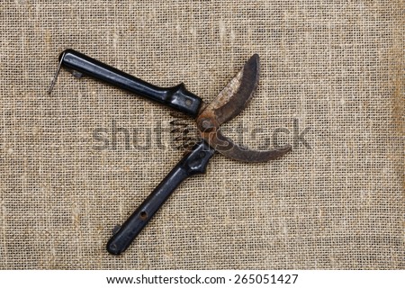 Old and rusty garden pruner on a sackcloth