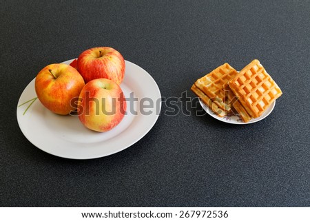 Apples and cookies on dark table. Make Your Choice.