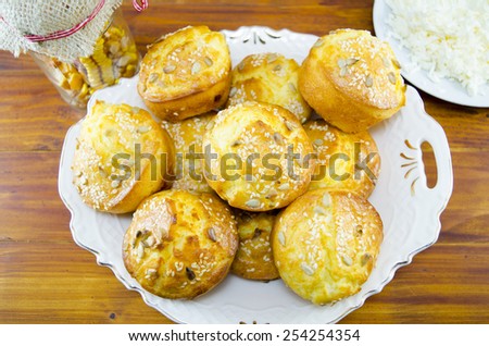 Plate full of corn bread muffins and a plate on a table