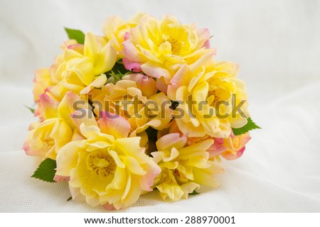 Bouquet of yellow roses on a white silken sheet