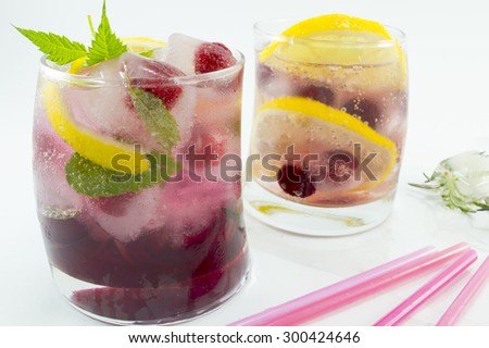Natural homemade red forest fruit iced-T juice with ice, lemon and sliced fruits