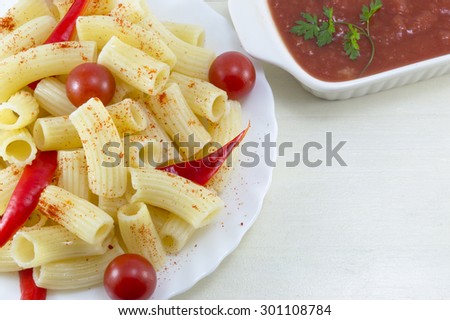 Pasta with cherry tomatoes and red pepper served with a tomato sauce close up
