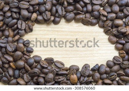 Coffee beans on a wooden table with round copyspace. Coffee background