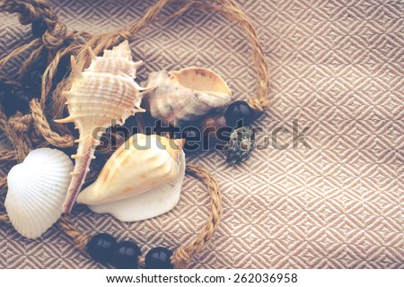 Vintage background with sea shells on natural textile, retro filtered with grain on high resolution