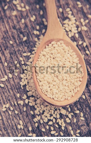 Vintage Dried Sesame Seeds in Wooden Spoon on Rustic Wooden Background. Super Still Life Photography. Organic Food and Healthy Lifestyle image. Retro Filter used.