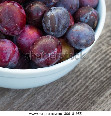 Fresh Organic Plums on Rustic Wooden Background. Retro Filter Effect. Vintage Style Harvest Background. Toned image with selective focus.