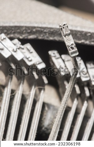 Closeup to typebars of an antique mechanical desktop spanish typewriter with the spanish letter Ã?Â?? up