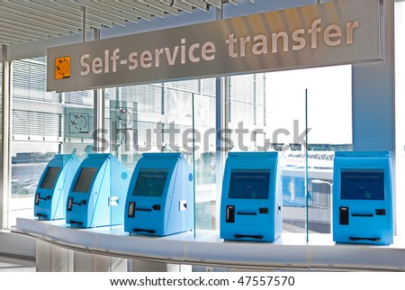 A row of self service check in machines in an airport
