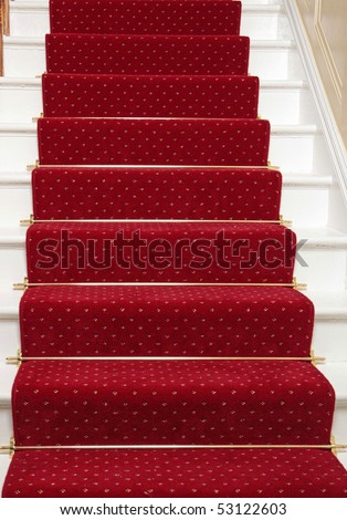 A red stair carpet with traditional brass rods
