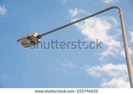 a street light pole with a blue sky background.