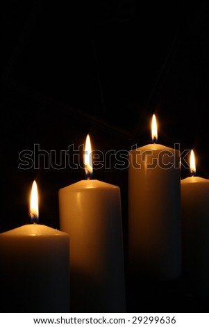 Four candles lit in the dark.