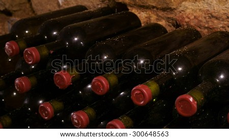 old red wine bottles aging in a wine cellar