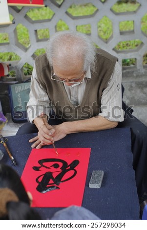 HANOI, VIETNAM, FEB 20 Old master is writing ancient letter for everyone in lunar new year on February 20, 2015 in Hanoi, Vietnam. This is a tradition of vietnamese people in lunar new year