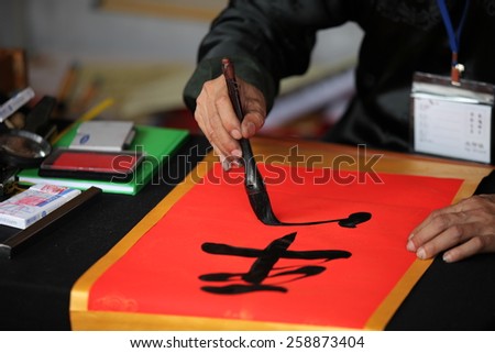 Hanoi, Vietnam - Feb 19, 2015 Calligrapher writing words on paper. Calligraphy is old culture of Vietnam