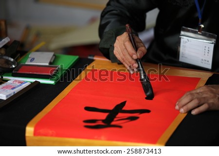 Hanoi, Vietnam - Feb 19, 2015 Calligrapher writing words on paper. Calligraphy is old culture of Vietnam