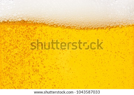 Pouring beer with bubble froth in glass for background on front view wave curve shape ,  drink alcohol celebration party holiday new year concept