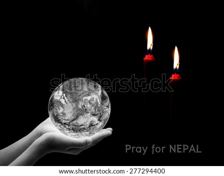 Hand holding earth and candle on black background , Pray for nepal ,  Elements of image are furnished by NASA