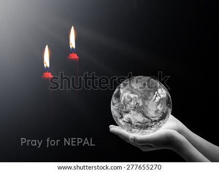 Hand holding earth and candle on black background , Pray for nepal , Elements of image are furnished by NASA