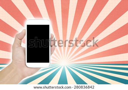 Hand holding White Smartphone on sun rays background