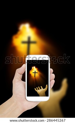 Hand holding smartphone on hand and cross background