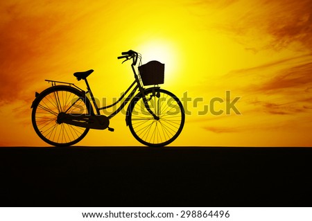 Bicycle silhouette on road and sunset , concept