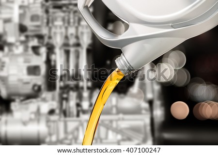 Pouring oil lubricant motor car from bottle on engine background
