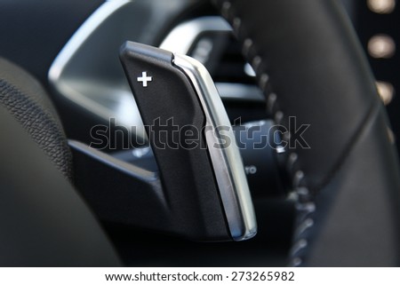 car gear lever, Close up shot of a manual gear changing paddle on a car\'s steering wheel.