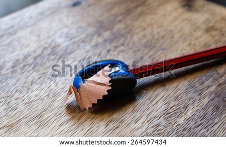 pencil sharpener and wood shaving on wood background