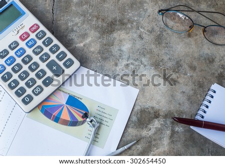 Business table.documents accounting graphs,calculator , glasses , pen and  notepad