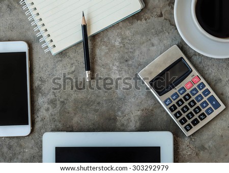 office business.smartphone, tablet, notepad , pencil ,calculator and coffee on concrete table background
