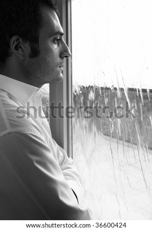 РЕАНИМАЦИЯ - Страница 3 Stock-photo-a-sad-man-is-watching-through-the-window-while-it-is-raining-36600424