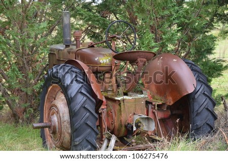 Rustic old tractor - an aged and unused old farm tractor rusting away on a farm.