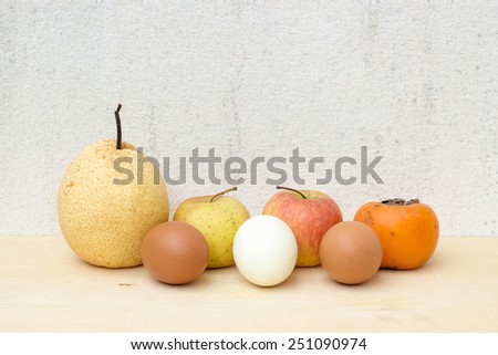 fruit group and egg still life on plywood and concrete wall