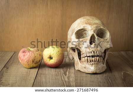 skull and sear fruit still life on wood background