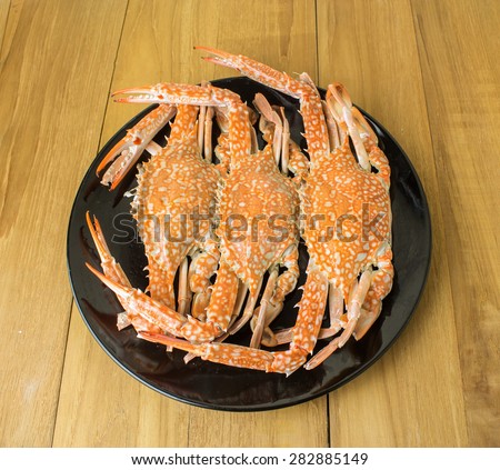 crab in black dish on wooden board
