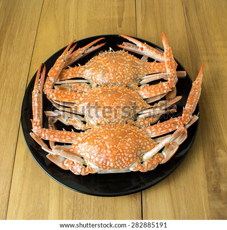 crab in black dish on wooden board