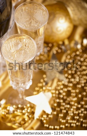 champagne in ice bucket against festive gold background