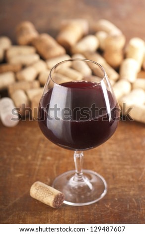 Dated wine bottle corks and red wine on the wooden background. Close up