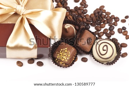 brown box with candies and golden tape, coffee grains on a white background