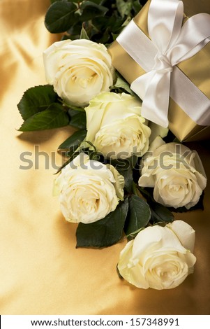 Rose with gift box on gold background