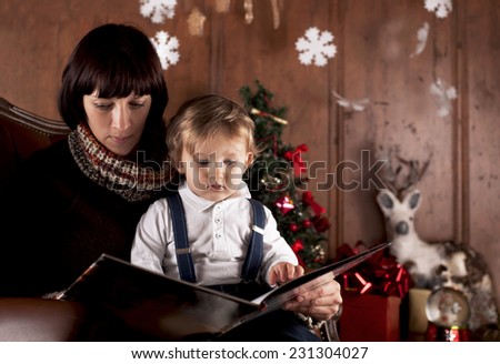 Christmas - Mother and her little child reading a book together